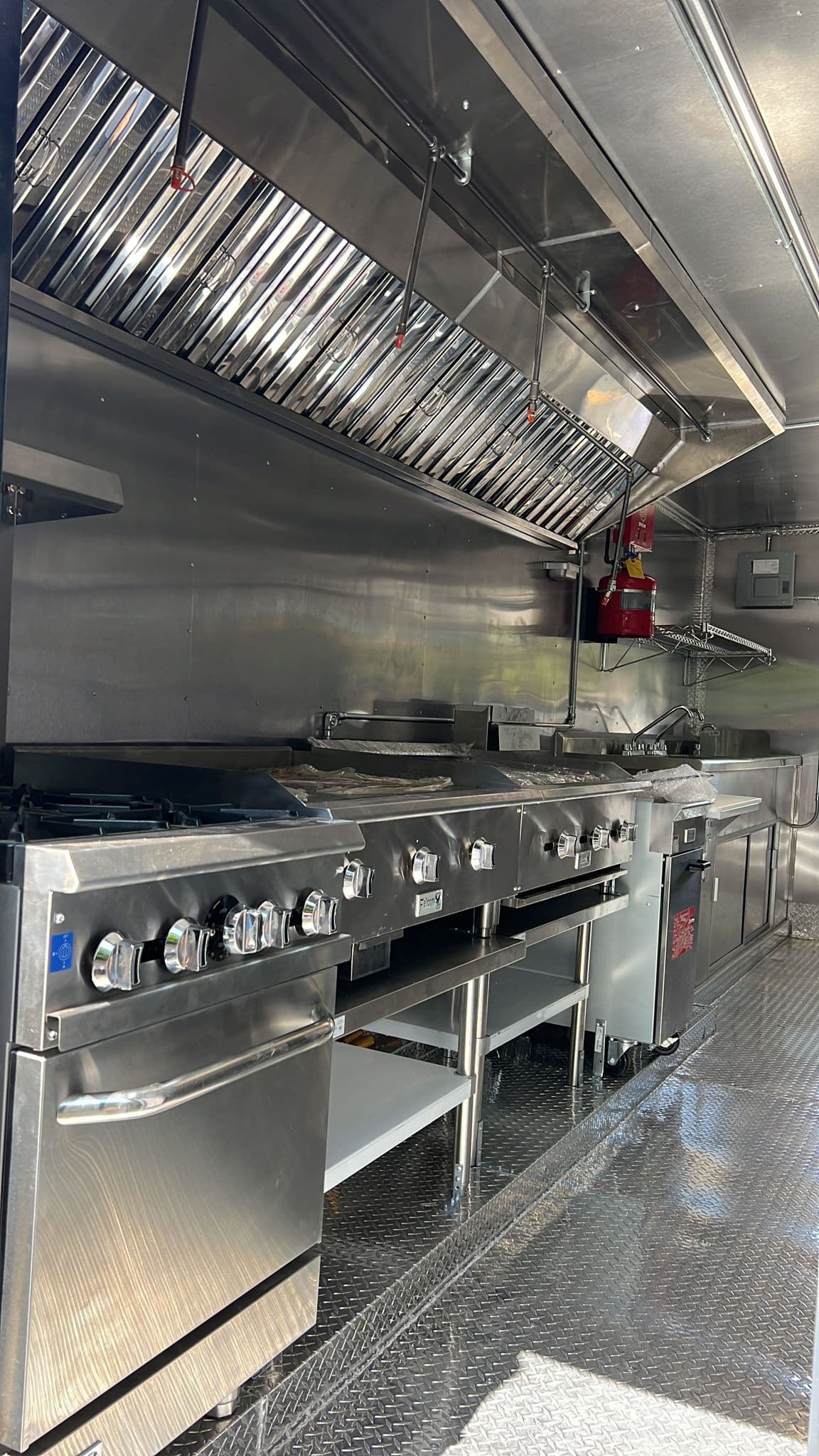 Stainless extraction hood above a commercial cook line