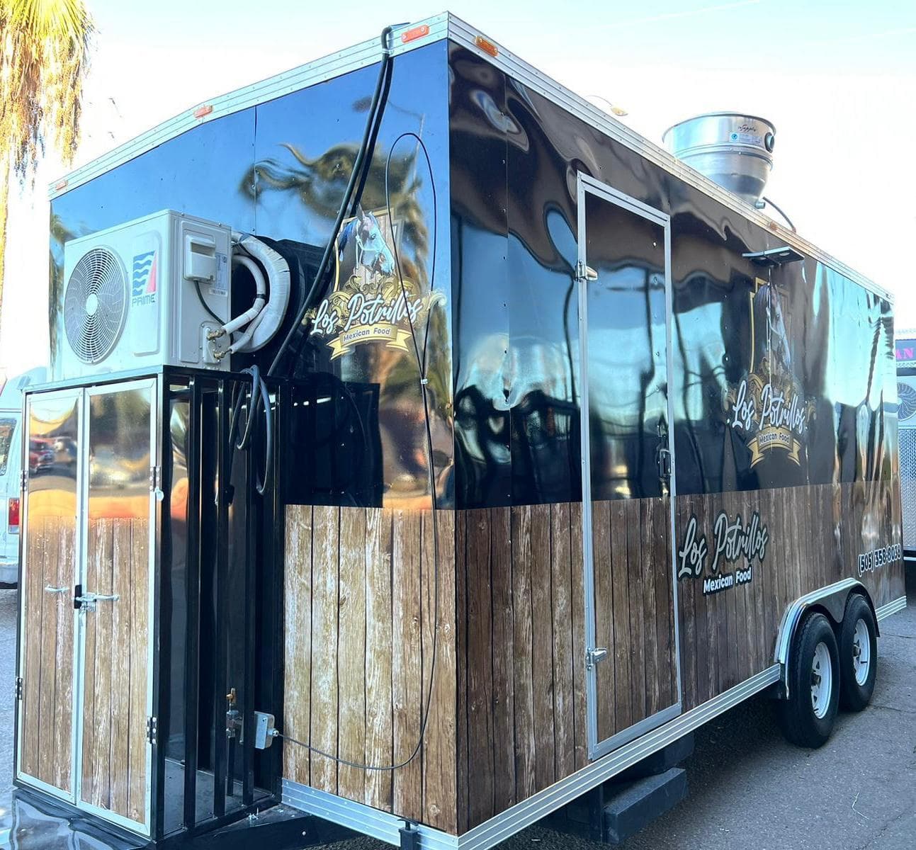 Finished food trailer in a full custom wrap, rear three-quarter view
