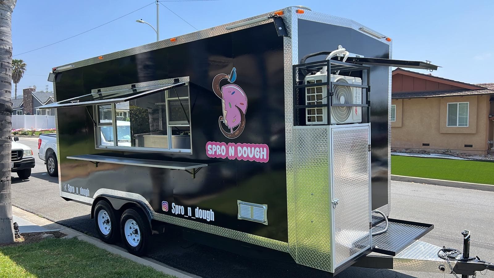 Custom food trailer set up and serving, window open, on location